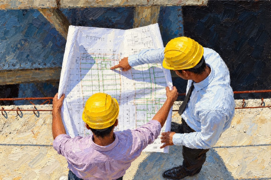 Two engineers in hard hats reviewing site plans